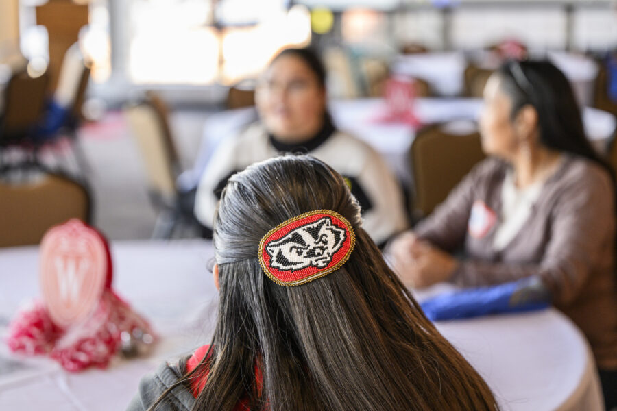 Lina Martin ’05, citizen of the Ho-Chunk and Stockbridge-Munsee Nations, AUNTIE (Advocate for Uplifting Native Traditions and Indigenous Engagement), PEOPLE Liaison, wears a beaded Bucky Badger hair clip during the Indigenous alumni social in the Alumni Lounge in the Pyle Center at the University of Wisconsin–Madison on Nov. 18, 2023. (Photo by Althea Dotzour / UW–Madison)